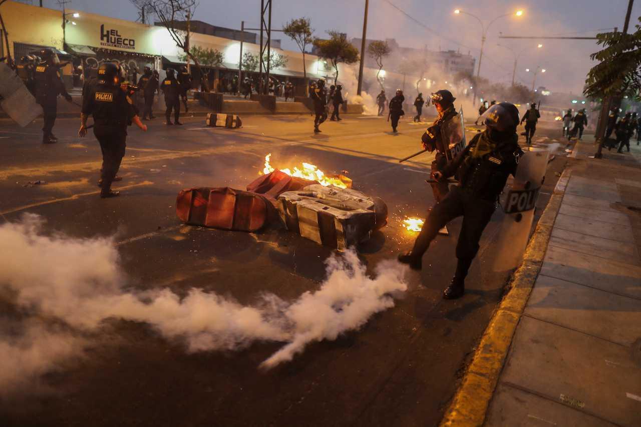 Riot police kick a tear gas canister during a protest demanding presidential elections and the closure of Congress after ousted Peruvian leader Pedro Castillo was detained in a police prison following his removal from the office, in Lima, Peru Dec 9. Photo: Reuters