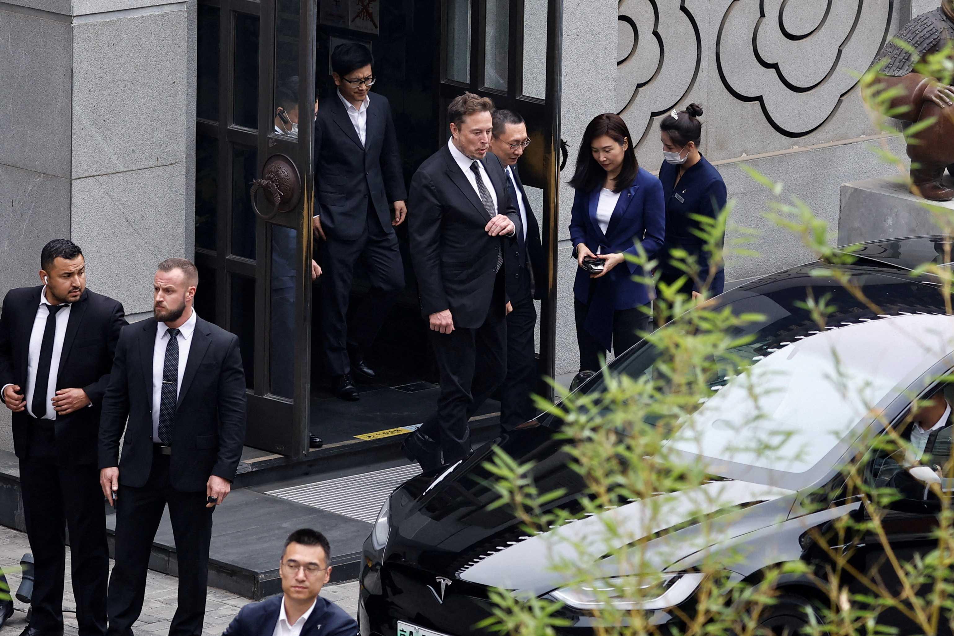 Tesla Chief Executive Officer Elon Musk walks next to Tesla Senior Vice President Tom Zhu and Vice President Grace Tao as he leaves a restaurant in Beijing, China May 31. Photo: Reuters