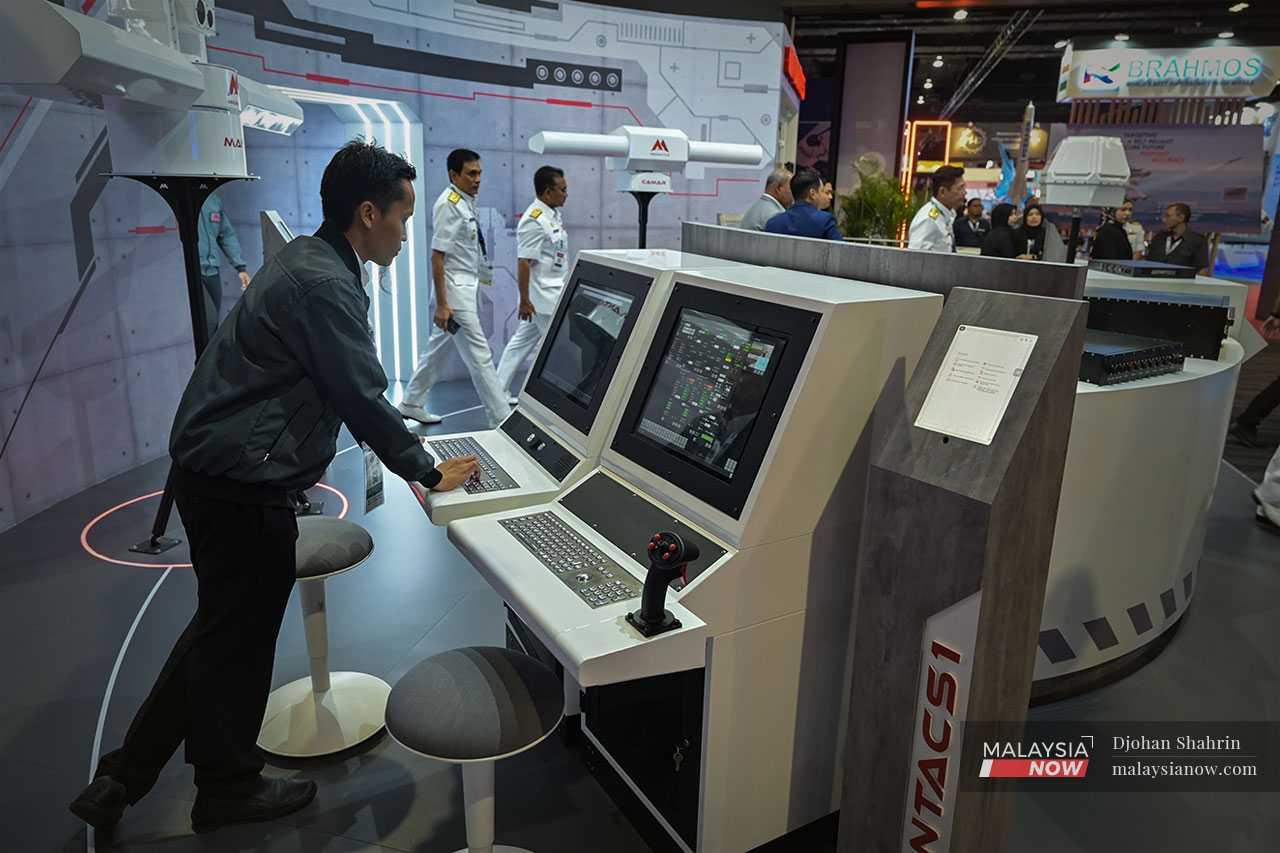 An attendant adjusts the settings of a shipping system on display.