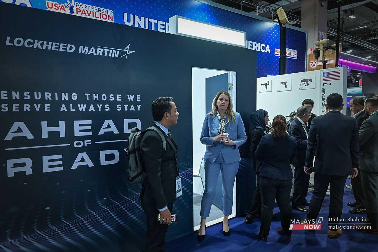 Kakitangan dari syarikat persenjataan dan aeroangkasa Lockheed Martin kelihatan di pintu masuk utama dewan pameran. Kehadiran firma itu pada pameran di Kuala Lumpur telah mencetuskan bantahan daripada beberapa kumpulan berhubung kaitannya dengan Israel. 