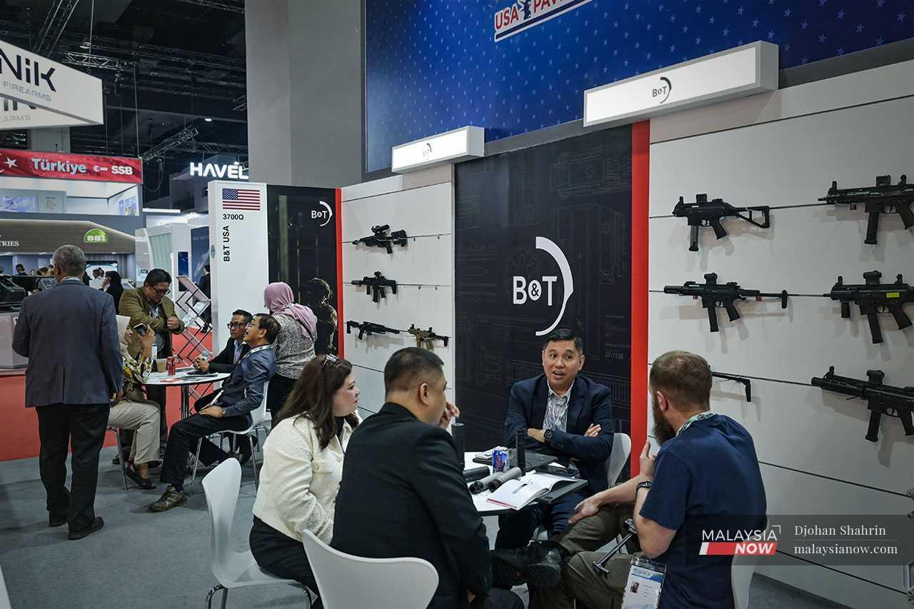 Visitors speak at the US-made B&T weaponry showroom.