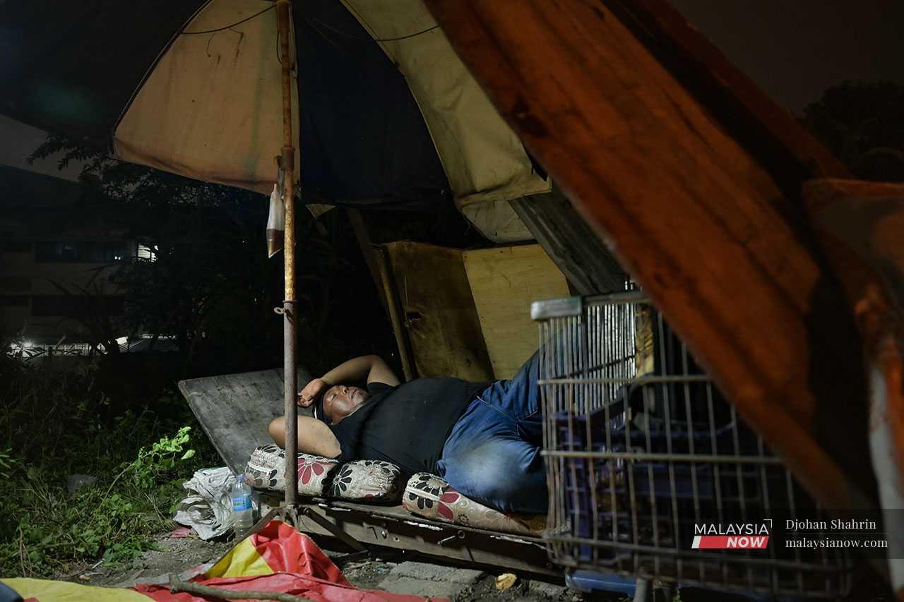 Rizuan Saawan tidur di atas pangkin berbumbungkan payung selepas kehilangan rumahnya.
