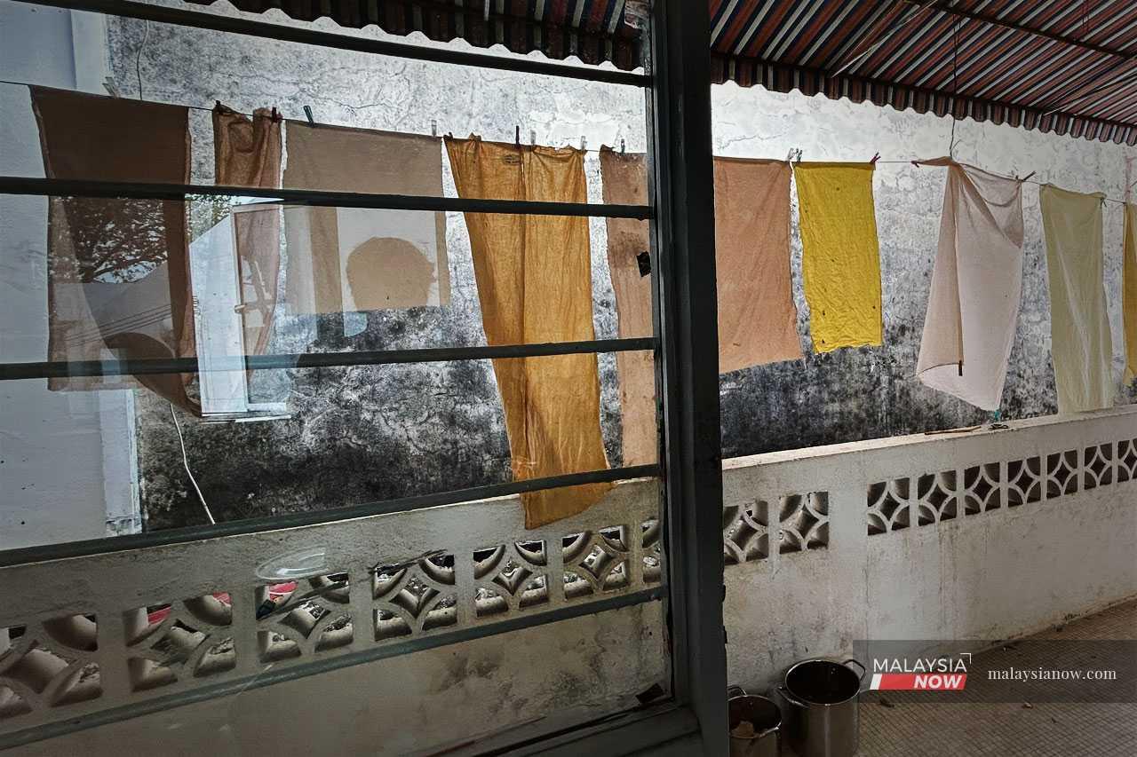 Once the colour is extracted, Ummi Junid uses the water to dye white cloth which is then hung up to dry.