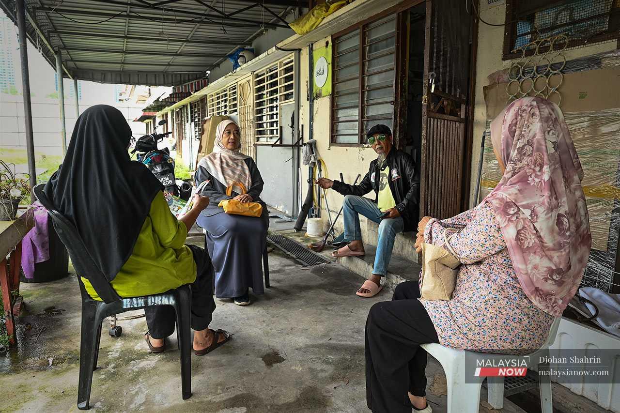 Anuar Ahmad, Rozana Aini dan beberapa penduduk lain berbincang sesuatu selepas dikejutkan dengan kehadiran jentera berat.