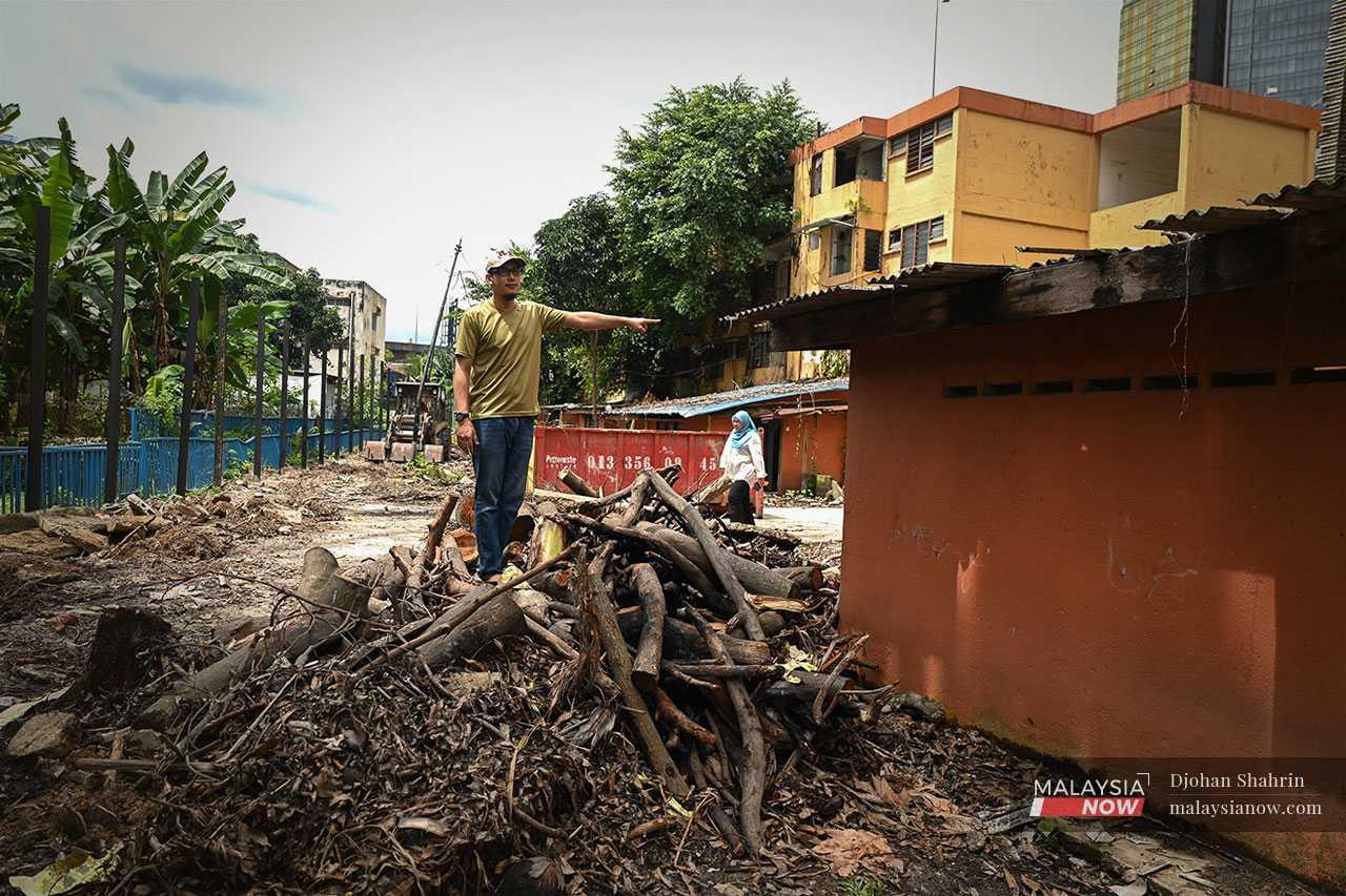 He points to some wood which was set on fire, nearly igniting the kitchen roof of a flat unit.