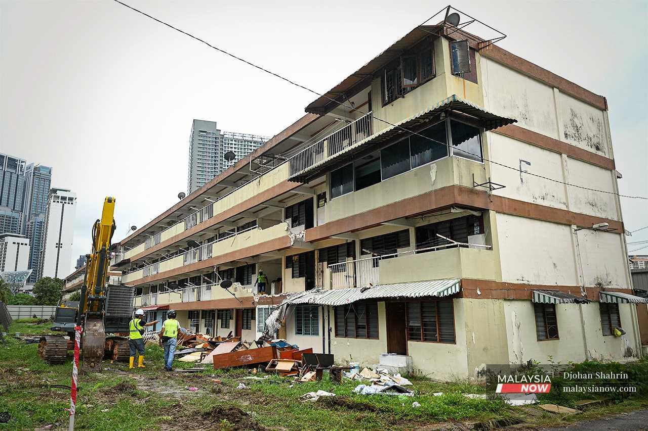 A bulldozer pauses from its work of tearing down a block of flats. The residents claim the developer is encroaching on their land and demolishing units that are still occupied.