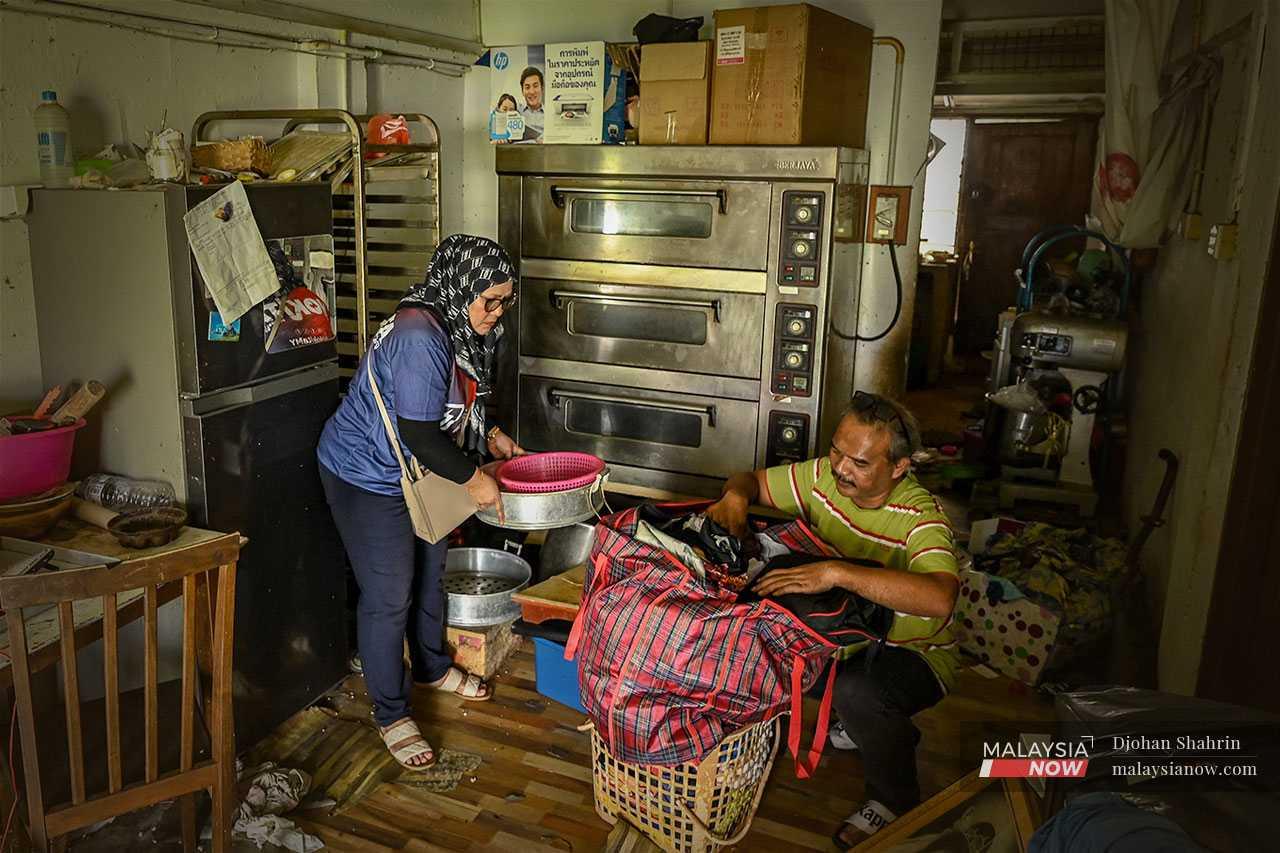 Pasangan penduduk Zura dan suami memeriksa barang mereka selepas menyedari rumah yang ditinggalkan dipecah masuk. Beberapa barang, termasuk motosikal dan basikal telah dicuri.