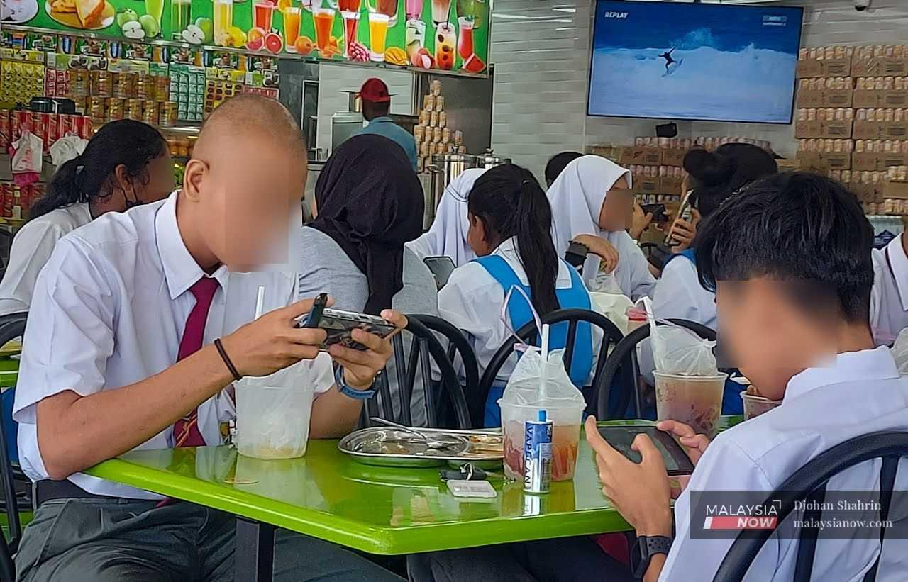 Two school students at a restaurant in Ampang, Selangor, with their vape devices placed on the table.