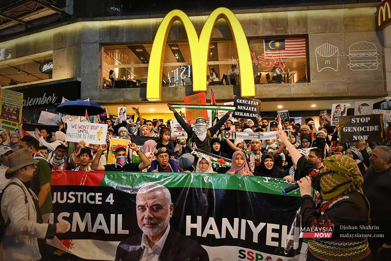 Perarakan berhenti di hadapan McDonald's Bukit Bintang, cawangan pertama jenama burger itu di Malaysia, yang turut menerima tempias kempen boikot kepentingan Amerika Syarikat di seluruh dunia.