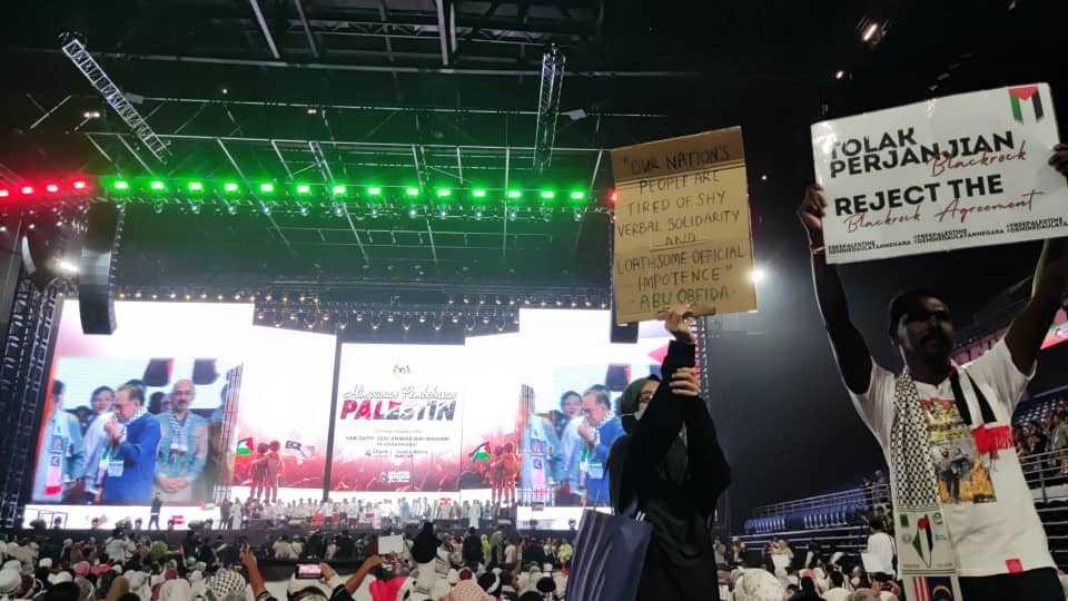 Mythreyar Mutturamalinggam and a fellow activist hold placards criticising the government's deal involving a company owned by BlackRock at the rally last night shortly before they were detained, in this picture shared by an X user.