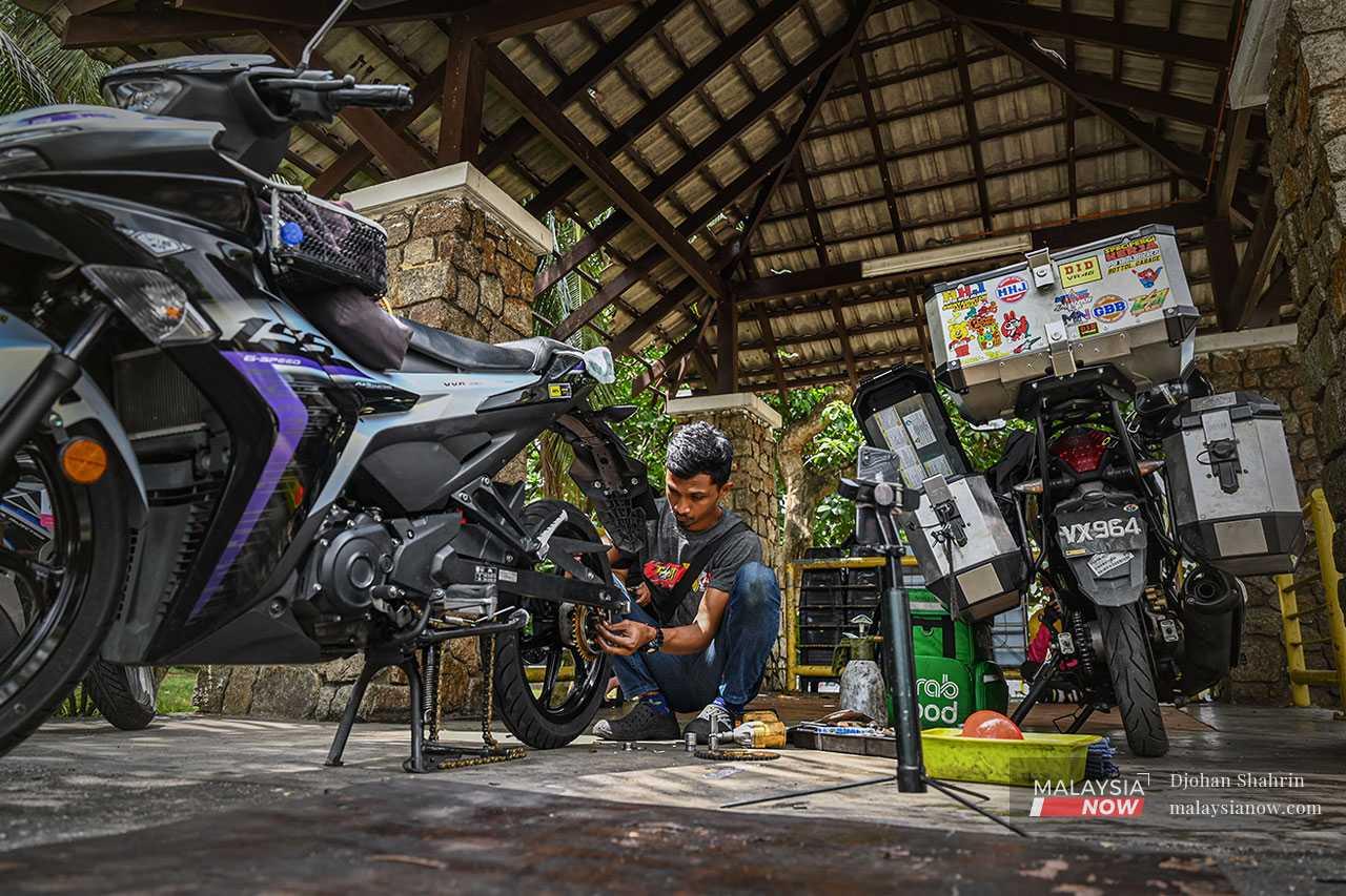 Yusof changes a set of chains on a 155cc Yamaha motorbike in Petaling Jaya while recording the video for his TikTok video.