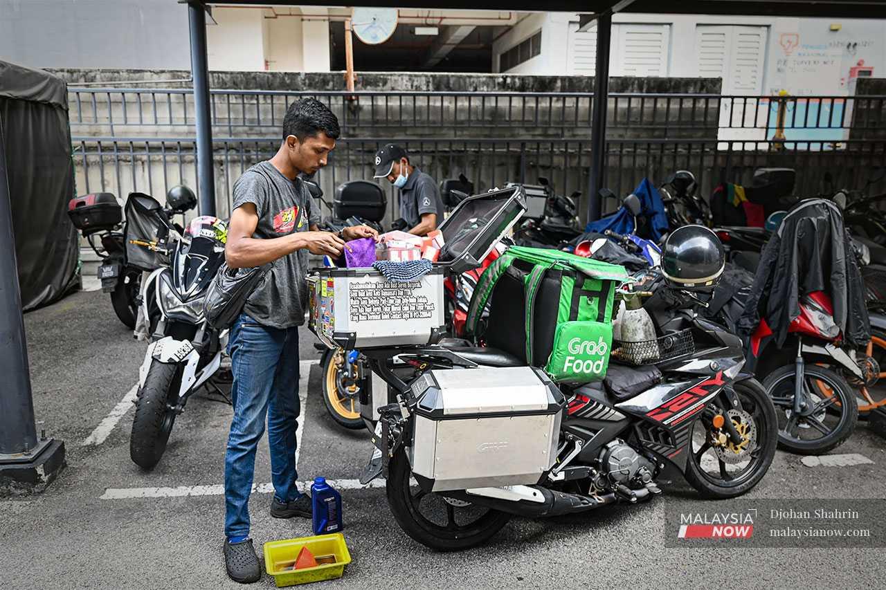 It's afternoon and Yusof prepares to for his second job: servicing motorbikes.