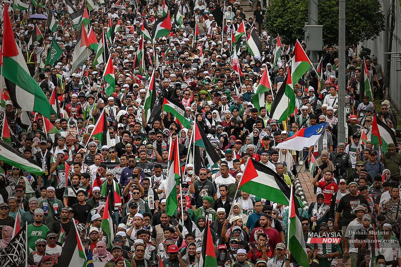 Bendera Palestin dikibarkan ketika bilangan peserta semakin meningkat selepas perarakan dihalang kira-kira 300 meter dari bangunan Kedutaan Amerika Syarikat.