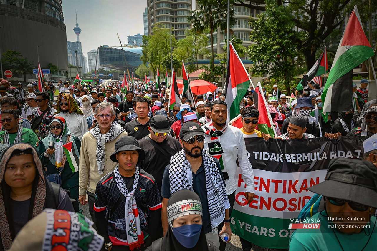 The gathering is organised by PAS and several other groups. Here, Pejuang president Mukhriz Mahathir, activist Tian Chua and lawyer Rafique Rashid join the march to the US embassy.