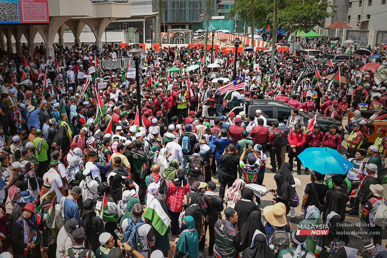 Thousands gather near the Asy-Syakirin Mosque next to the Petronas Twin Towers before marching to the nearby US embassy.