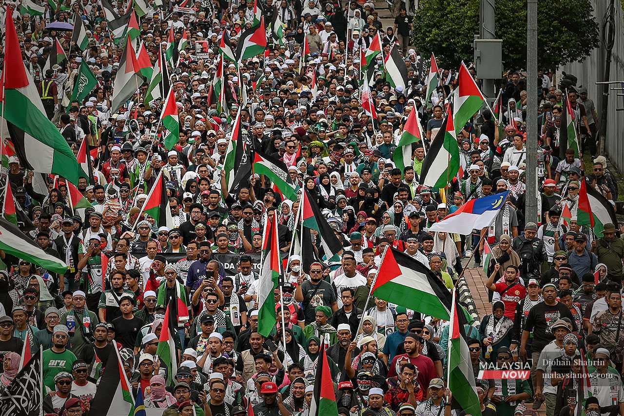 Ribuan peserta berarak menuju Kedutaan Amerika Syarikat di Kuala Lumpur sambil mengibarkan bendera Palestin dan memegang sepanduk solidariti.