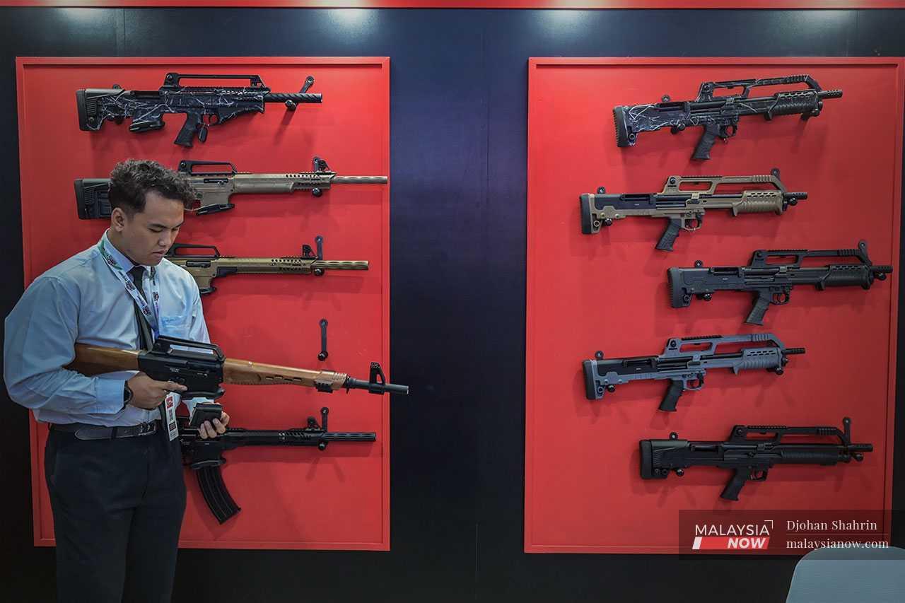 A man examines one of the guns on display at the exhibition which involved companies such as Lockheed Martin and BAE Systems.