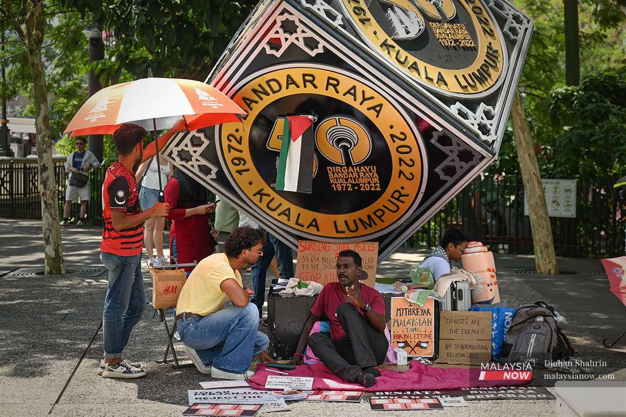 Mythreyar explains his efforts to a tourist from Sri Lanka who stops to inquire about his hunger strike.