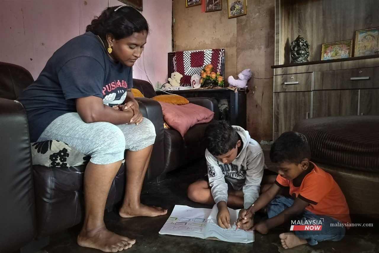 Mariamar's children do their homework on the floor in the living room.