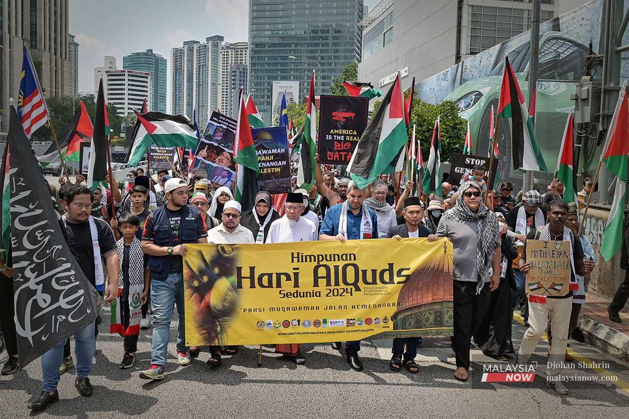 Mythreyar and NGO representatives head towards the US embassy in Kuala Lumpur to hand over a memorandum against the violence towards Palestinians in April.