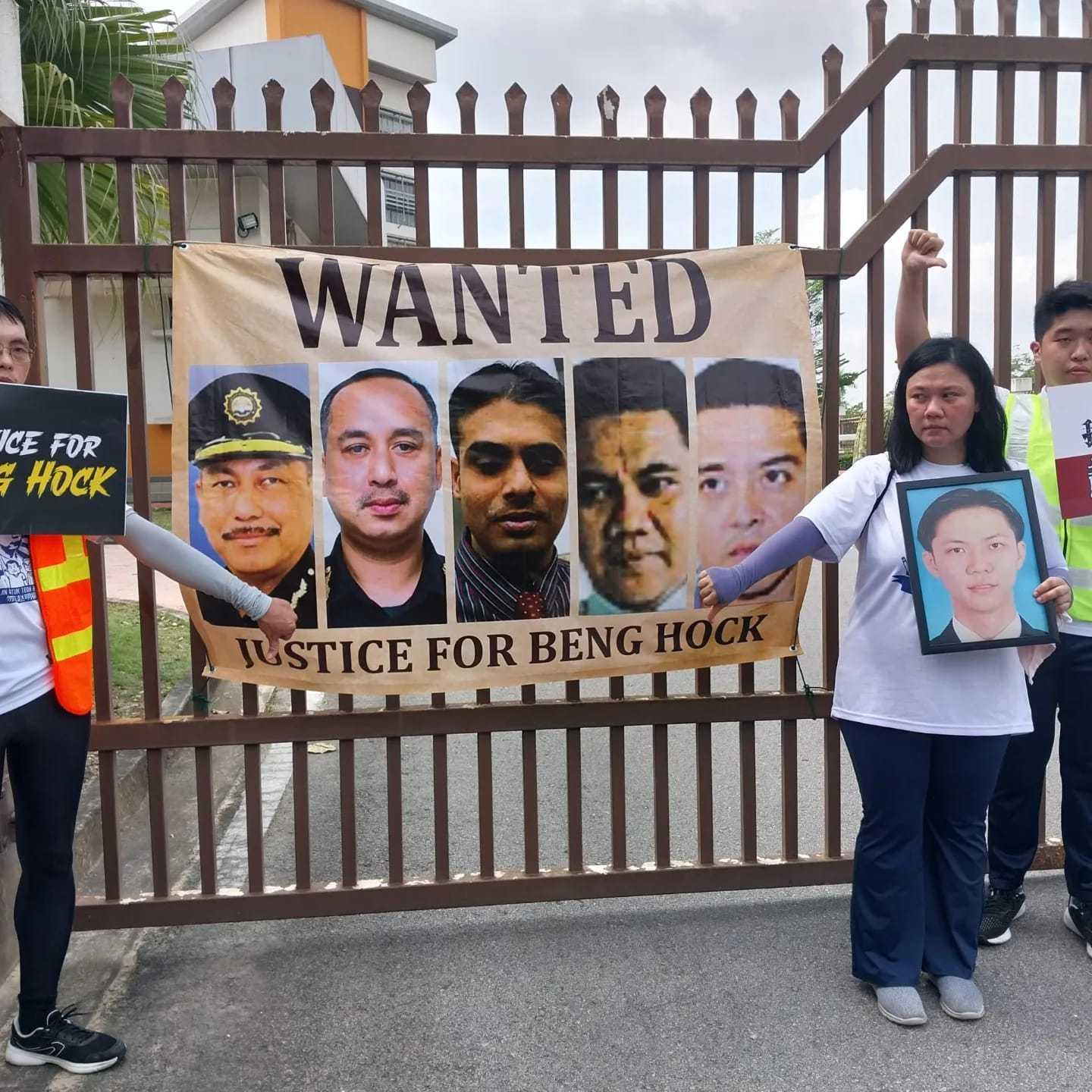 Family members of Teoh Beng Hock outside the Parliament in July 2024, with a banner showing Hishamuddin Hashim and other MACC officers implicated in the 2009 death of the late DAP officer.