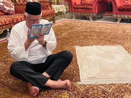 Najib Razak reads from a chapter of the Quran at his house, as he invites supporters to join him in a virtual prayer session ahead of his appeal decision tomorrow. Photo: Facebook