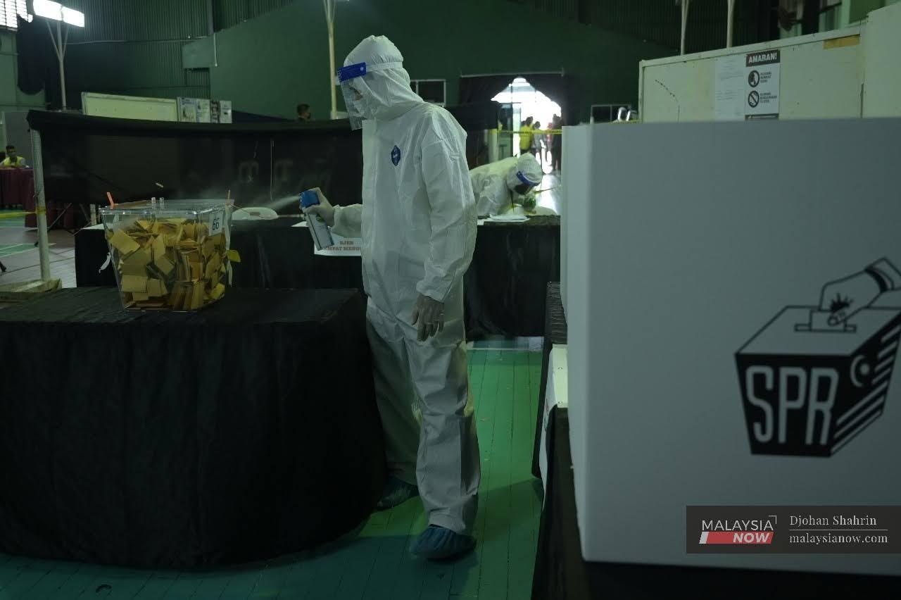 Election Commission workers spray sanitiser at a polling centre during the recent Sarawak state election.