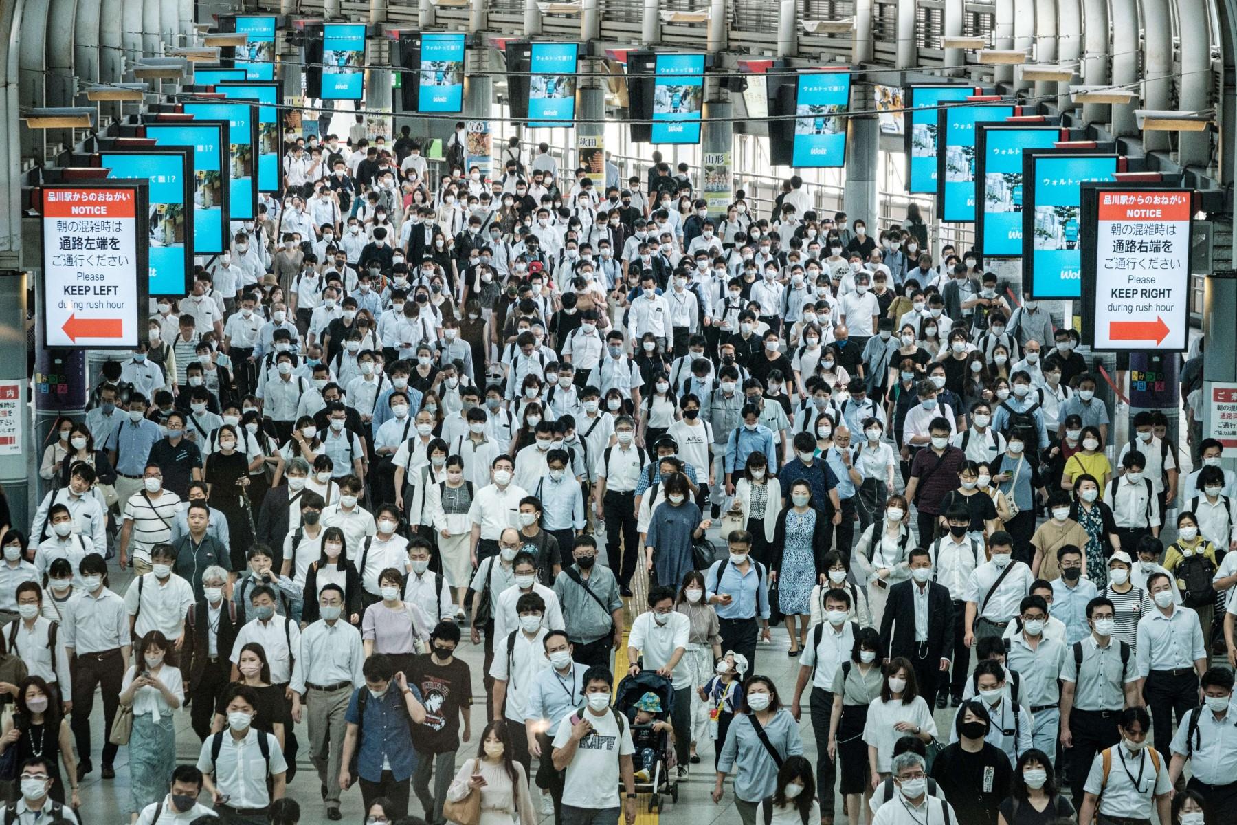 Commuters wear masks at a train station in Tokyo on July 28, 2021. Photo: AFP