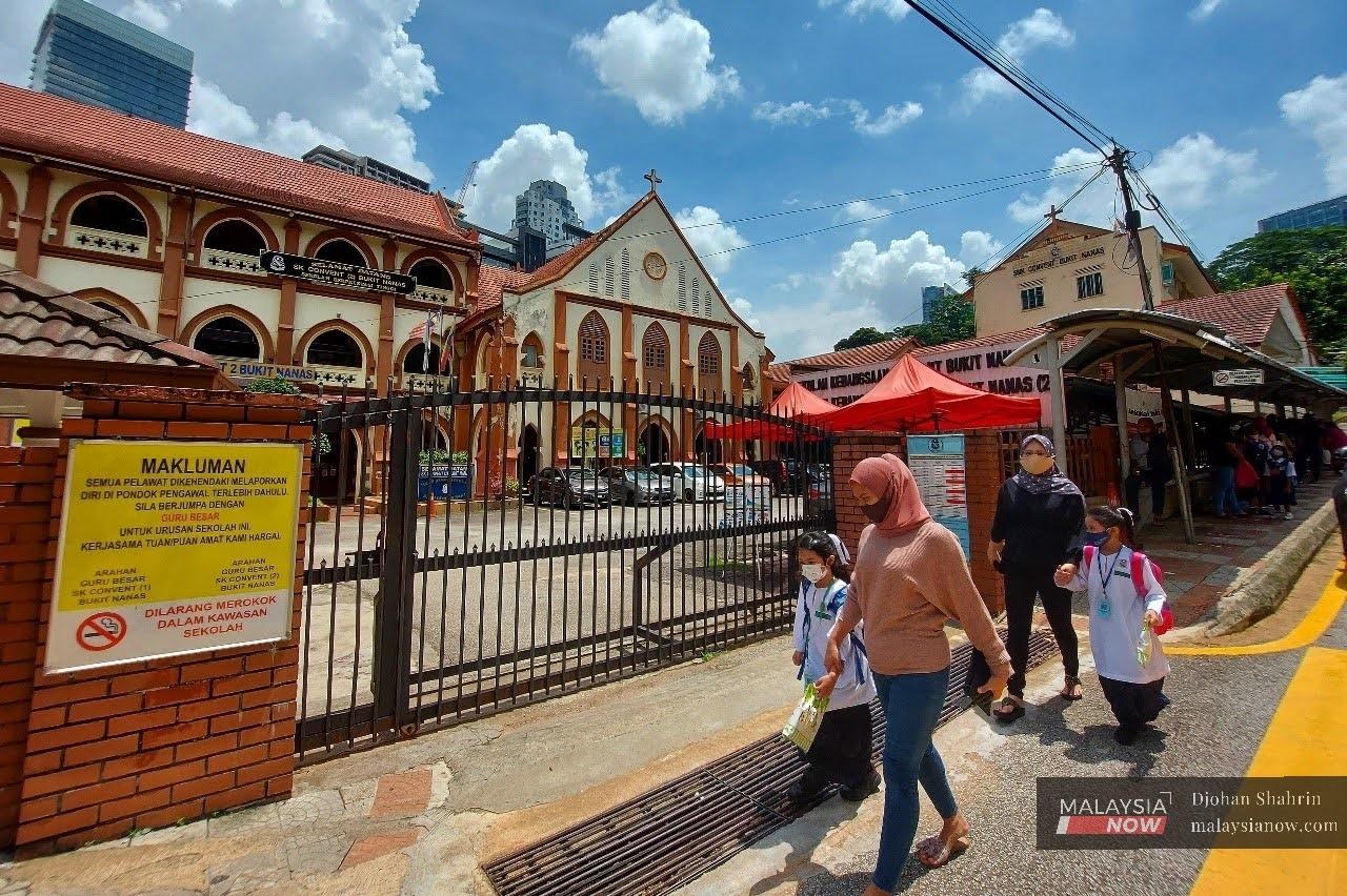 Parents pick up their children from the Convent Bukit Nanas girls' school in Kuala Lumpur today. Established in 1899, the school is said to be one of the oldest in the country.